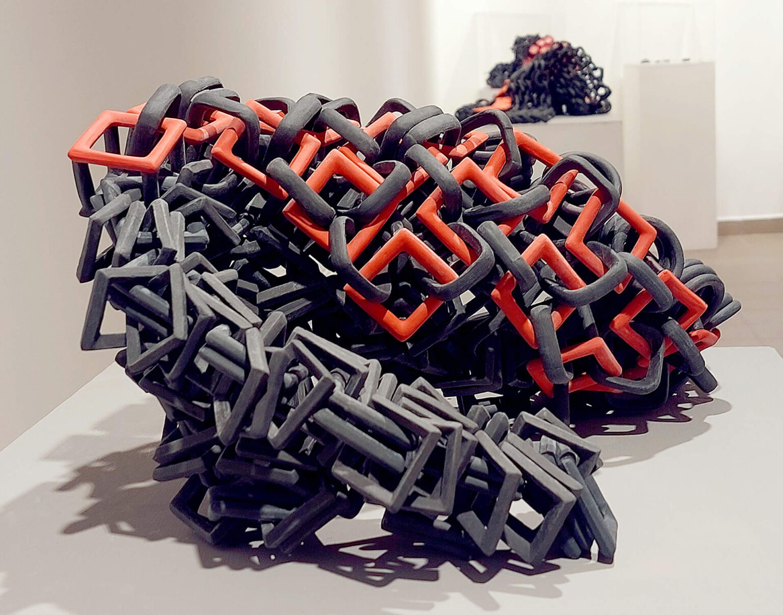 Rejka Erika In-Perfect című kiállításának enteriőrje a B32 Galéria és Kultúrtér Trezor Galériájában; (előtérben) Liaison 0,5.I.II. – mobil porcelánplasztika; öntött porcelánszemek égetés előtt összefűzve